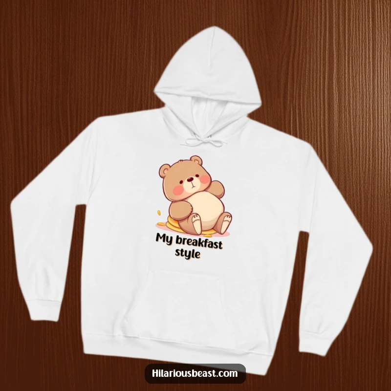 Funny bear hoodie, a chubby bear tripping playfully with a stack of pancakes askew, radiating adorable clumsiness and breakfast enthusiasm.