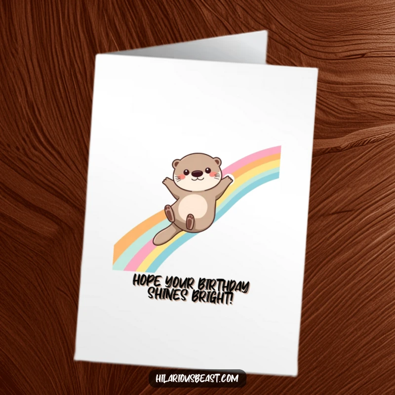 Funny Free Printable Birthday Card: A cute otter slides down a vibrant rainbow, arms outstretched for balance, embodying pure joy and birthday magic.