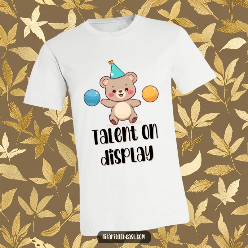 Funny t-shirt featuring a tiny bear cub with a party hat, joyfully juggling three vibrant balls, capturing a moment of playful chaos.